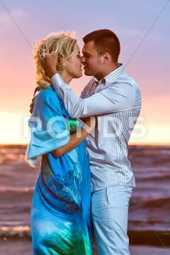 Beautiful young couple in love near the sea at sunset Stock-Fotos