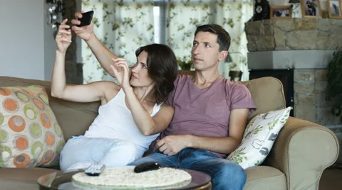 Beautiful young couple is making selfie using a smart phone and smiling while Stock Footage 65990956