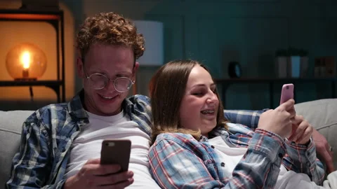 Beautiful young couple using smart phone, sit on sofa at home 库存影片 166099825