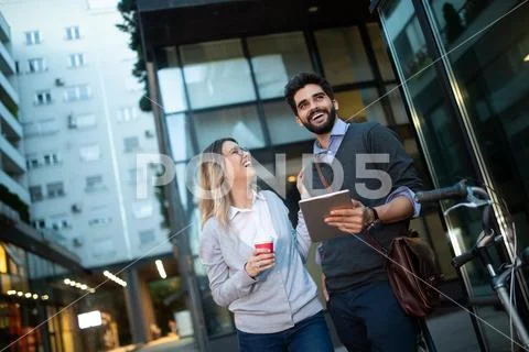 Beautiful young couple walking down the street with tablet Stock Photos