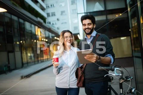 Beautiful young couple walking down the street with tablet Stock Photos