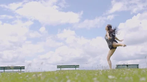 Beautiful young dancer dances on grass outdoors, in slow motion Stock Footage 76921969