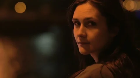 Beautiful young dark-haired woman softly looking into camera. Darkness all Stock Footage