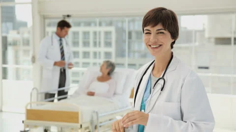 Beautiful Young Doctor Taking Notes in a Hospital Room Stock Footage 891606