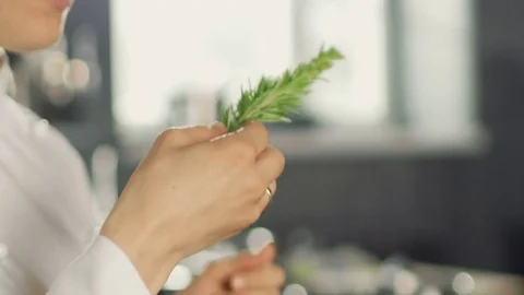 Beautiful Young Female Chef Smells Decorative Spice Plant. Stock Footage