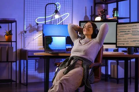 Beautiful young female programmer resting at her workspace in modern office a Stock Photos