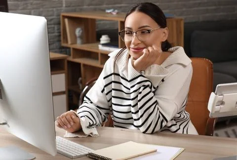 Beautiful young female programmer working with computer in modern office Stock Photos