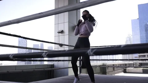 Beautiful young girl boxer dynamically trains punches, boxing in the ring on the Stock Footage 120116186