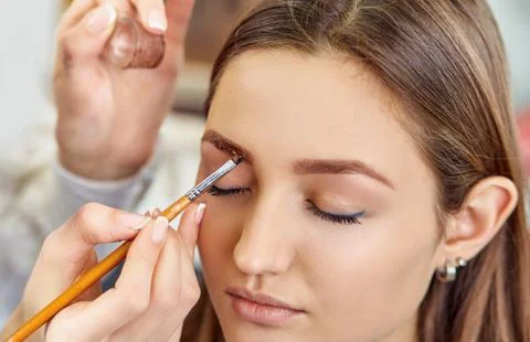 Beautiful young girl dyed her eyebrows in a beauty salon Stock Photos