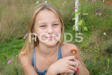Beautiful young girl with a flower in the park Stock Photos