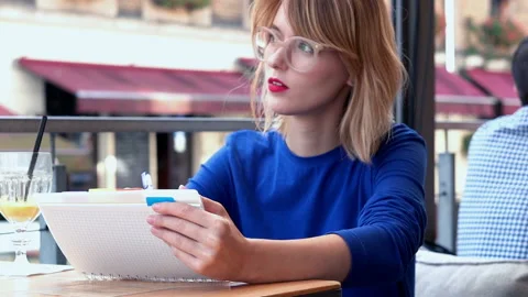 Beautiful young girl making notes in cafe in the city, 4K Видео 99251765