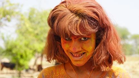 Beautiful young girl posing with exploding pink and yellow Holi powder arou.. Stock Photos