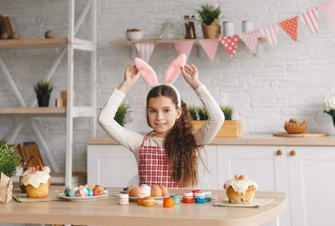 A beautiful young girl is preparing for the Easter holiday holding her hands  Stock Photos