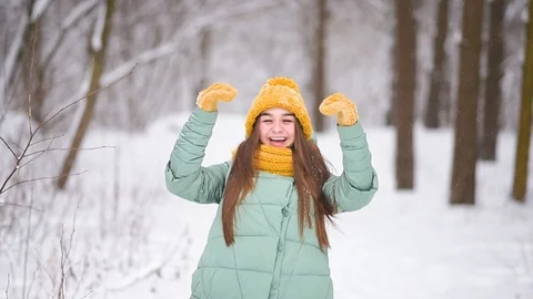 Beautiful young girl shows "class" in mittens, winter forest Stock Footage