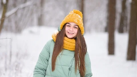 Beautiful young girl smile in knitted hat on winter forest background Stock Footage
