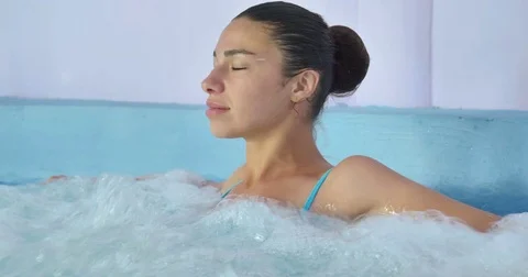 Beautiful young girl (woman) relaxed in a hydromassage bath Stock Footage