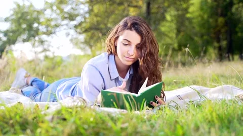 Beautiful young lady reading book at summer park Stock Footage 140122334