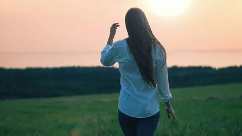Beautiful young lady walking in fields during sunset Stock Footage 80291767