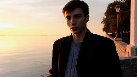 Beautiful young man portrait looking at sunset on the sea Stock Footage 87925675