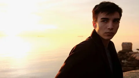 Beautiful young man portrait looking at sunset on the sea Stock Footage 88123797