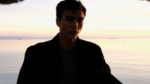 Beautiful young man portrait looking at sunset on the sea Stock Footage 88188917