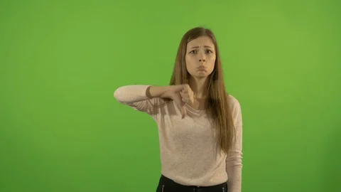 Beautiful young model on a background of a green screen. Shows his thumb down Video stock 75685132