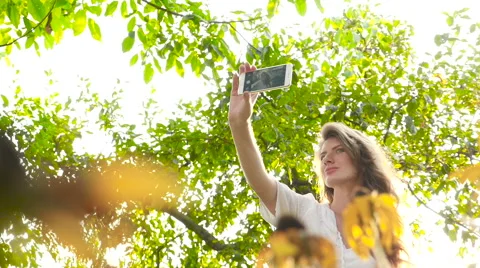 Beautiful young model making selfie near sunflowers. HD Stock Footage 67718965