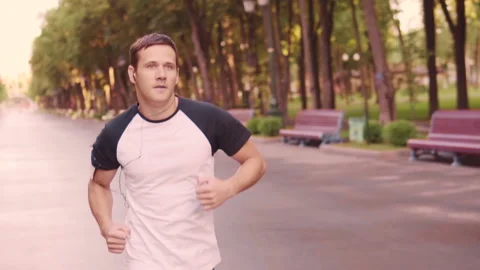 Beautiful young model men training runs in the Park, slow motion Stock Footage 93767048