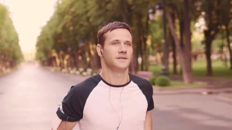 Beautiful young model men training runs in the Park, slow motion Stock Footage 93767085