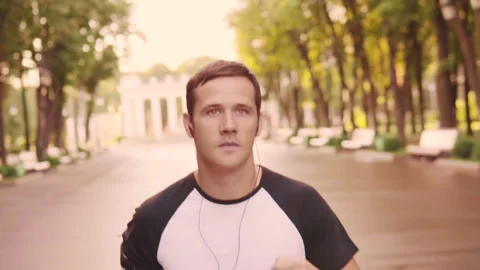 Beautiful young model men training runs in the Park, slow motion Stock Footage 93778734