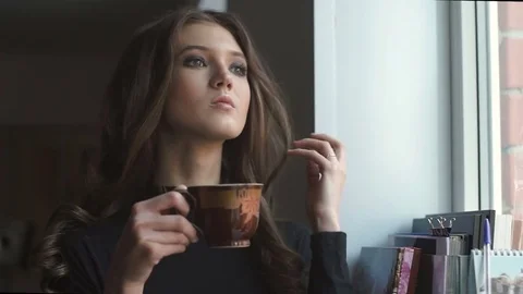 Beautiful young model standing next to the window and drinking coffe. Stock Footage 74123701