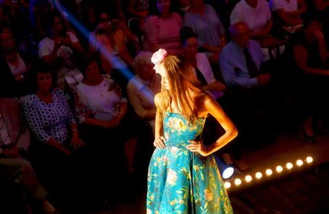 Beautiful young model walking down catwalk at fashion show. Fashion show in 스톡 사진
