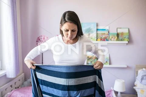 Beautiful young mother wrapping sling for baby around her Stock Photos