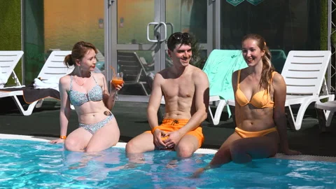Beautiful young people having fun in swimming pool. Clip. Friends communicating Stock Footage 254020429