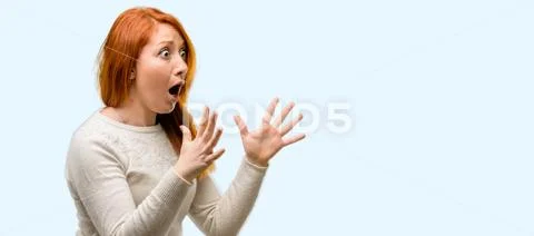 Beautiful young redhead woman stressful keeping hands on head, terrified in p Stock Photos