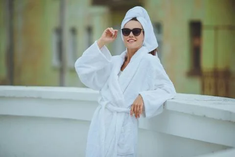 Beautiful young smiling girl in a white robe on the balcony Stock Photos