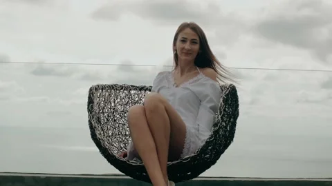 Beautiful young smiling long-haired girl rotates in a chair on a background of Stock Footage 130282963
