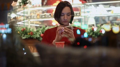 Beautiful young smiling using smartphone chatting online sitting in cafe Stock Footage 83082153