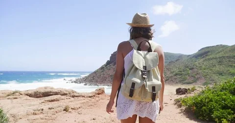 Beautiful young tourist (girl), in a white dress, looks, with a backpack Stock Footage