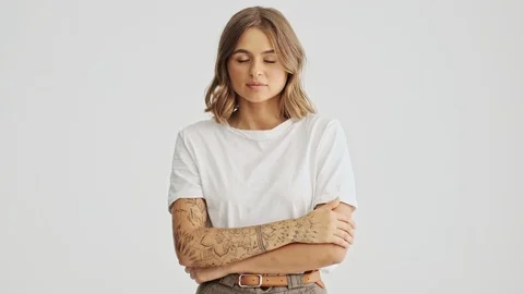 Beautiful young woman in basic t-shirt making a stop gesture over white wall Stock Footage 120069609