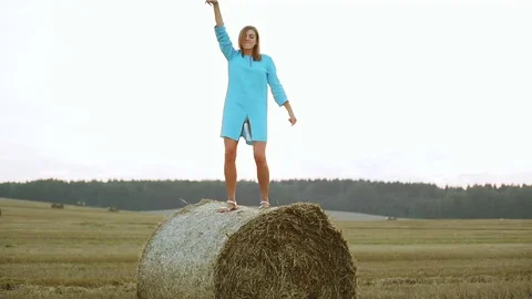 Beautiful young woman dancing in a haystack. Stock Footage 69950491