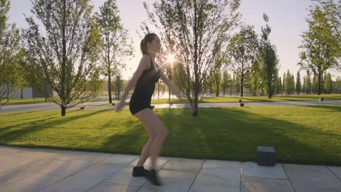 Beautiful young woman doing sports exercises in the park at dawn Stock Footage