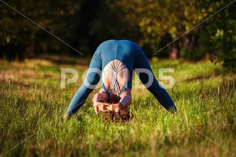 Beautiful yoga girl doing asanas in studio Stock Photo by