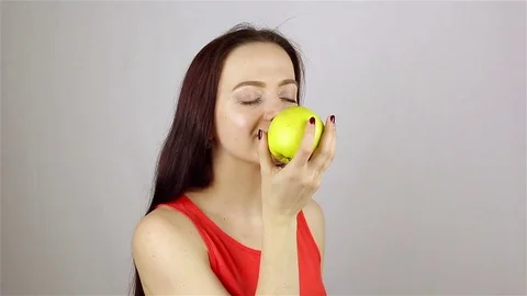 Beautiful young woman eating an apple Stock Footage