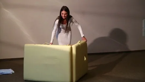 A beautiful young woman folds and puts a folding table in the bag for massage Stock Footage
