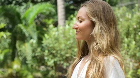 Beautiful young woman with long blond hair takes a deep breath Stock Footage