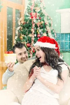 Beautiful Young Woman Looking Gift Box and Smiling While Her Boyfriend Stock Photos