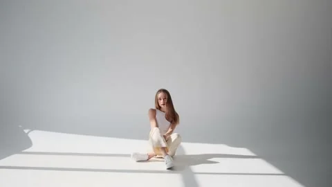 Beautiful young woman posing while sitting on floor 스톡 동영상 164536761