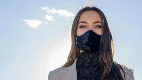 Beautiful young woman in a protective medical mask. Stock Photos
