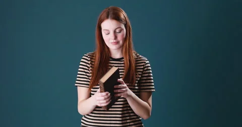 Beautiful young woman with red hair reading a book Stock Footage